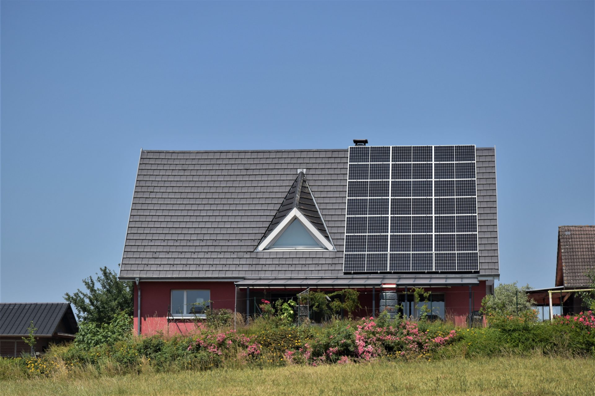 Die Hälfte des Schrägdaches eines Einfamilienhauses ist mit Solarpanelen belegt.